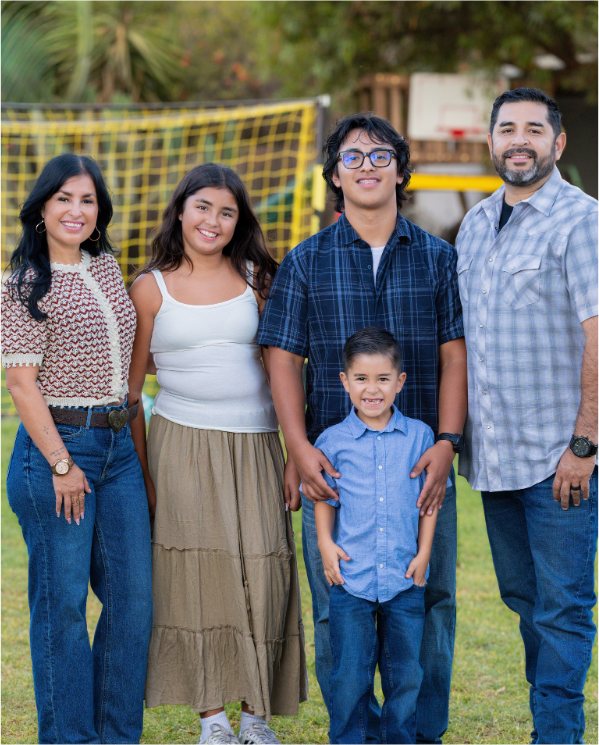 Adriana Gonzalez with her husband and three children on a grassy field
